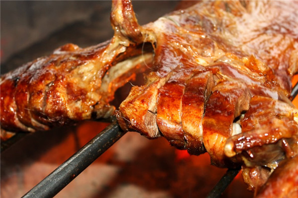 羊大?？救? /><p>在這里吃烤全羊，首先要預(yù)定，因?yàn)樗鼜?fù)雜的程序，一般臨時(shí)去，是很難烤出來(lái)的。這里的羊都在20-40多斤左右，而且必須是來(lái)自高山野林的嫩羊。這些羊在你預(yù)定后，才開始宰殺，然后，碼上各種調(diào)料，腌制1個(gè)小時(shí)，待調(diào)料入味，才開始烤制。</p><p>烤羊必須是炭火，邊烤還要邊刷調(diào)料，漸漸地羊肉的香味出來(lái)啦，表皮也變得焦酥，色澤十分金黃，這樣的慢火烤制，至少需要3個(gè)鐘頭。當(dāng)你和你的朋友，圍坐好后，烤好的全羊，可以抬上來(lái)，整只冒著熱氣，流著羊油，閃著誘人食欲光澤的全羊，靜靜地?cái)[在你的面前，上面還覆蓋著一層翠綠的蔥花。</p><img src=